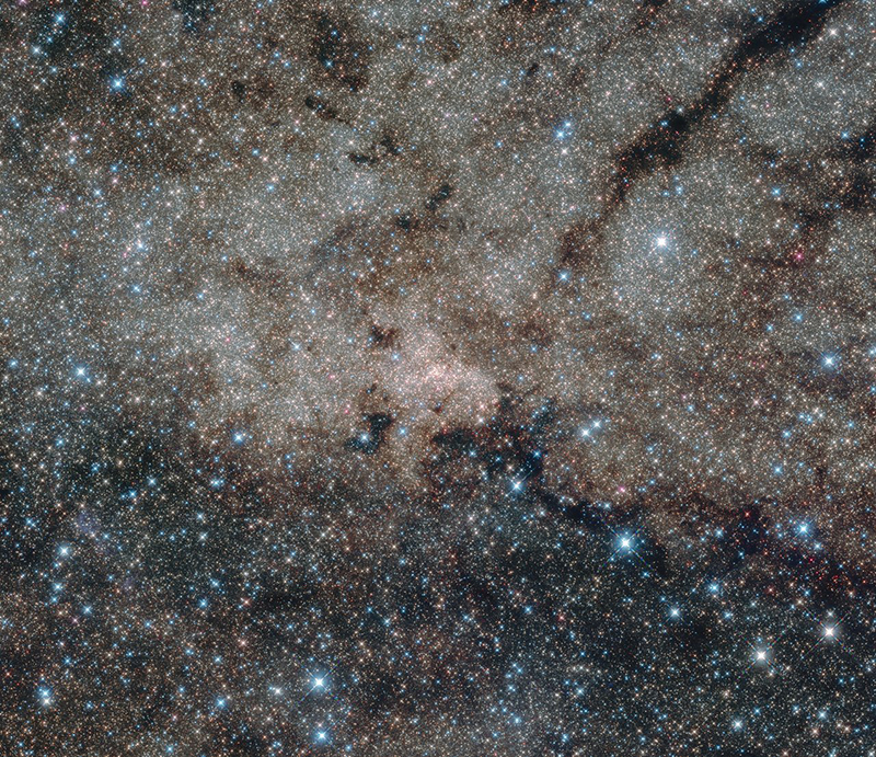 This infrared image from the NASA/ESA Hubble Space Telescope shows the centre of the Milky Way, 27 000 light-years away from Earth. Using the infrared capabilities of Hubble, astronomers were able to peer through the dust which normally obscures the view of this interesting region. At the centre of this nuclear star cluster — and also in the centre of this image — the Milky Way’s supermassive black hole is located.