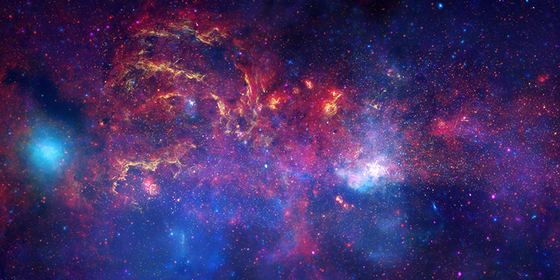 In celebration of the International Year of Astronomy 2009, the NASA/ESA Hubble Space Telescope and its companion Great Observatories: the Spitzer Space Telescope and the Chandra X-ray Observatory have collaborated to produce an unprecedented image of the central region of our Milky Way galaxy. In this spectacular image, observations using infrared light and X-ray light see through the obscuring dust and reveal the intense activity near the galactic core. Note that the centre of the galaxy is located within the bright white region to the right of and just below the middle of the image. The entire image width covers about one-half a degree, about the same angular width as the full moon. Each telescope's contribution is presented in a different colour:  Yellow represents the near-infrared observations of Hubble. They outline the energetic regions where stars are being born as well as reveal hundreds of thousands of stars.  Red represents the infrared observations of Spitzer. The radiation and winds from stars create glowing dust clouds that exhibit complex structures from compact, spherical globules to long, stringy filaments. Blue and violet represent the X-ray observations of Chandra. X-rays are emitted by gas heated to millions of degrees by stellar explosions and by outflows from the supermassive black hole in the galaxy's centre. The bright blue blob on the left side is emission from a double star system containing either a neutron star or a black hole.  When these views are brought together, this composite image provides one of the most detailed views ever of our galaxy's mysterious core.