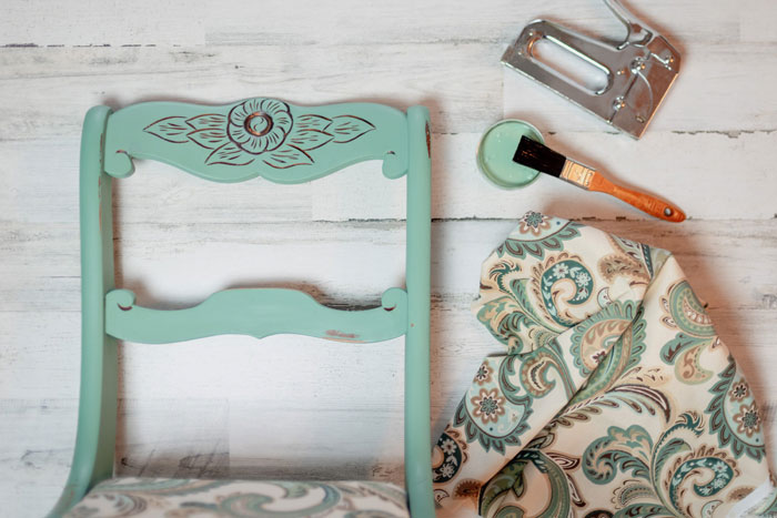 Чтобы облагородить старый стул, потребуется краска по дереву, ткань и мебельный степлер